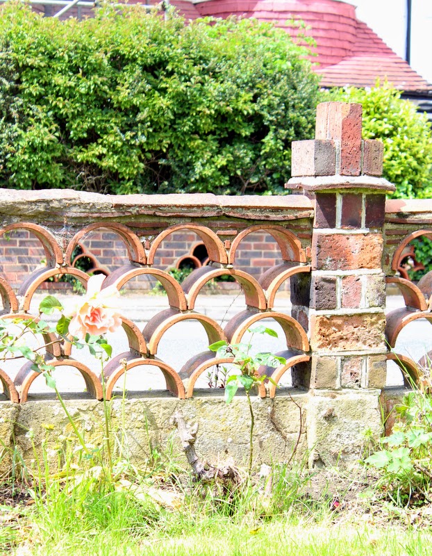 1930s house with red brick fence in the London suburbs.