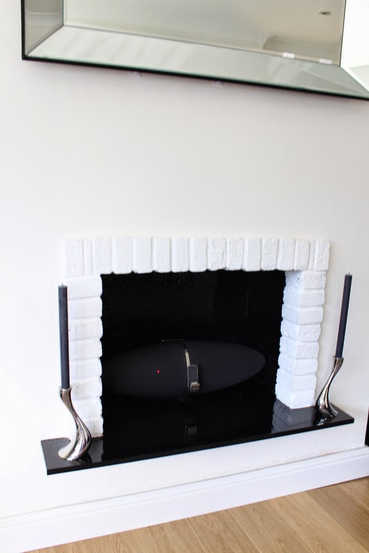 1930s original red brick fireplace painted white.