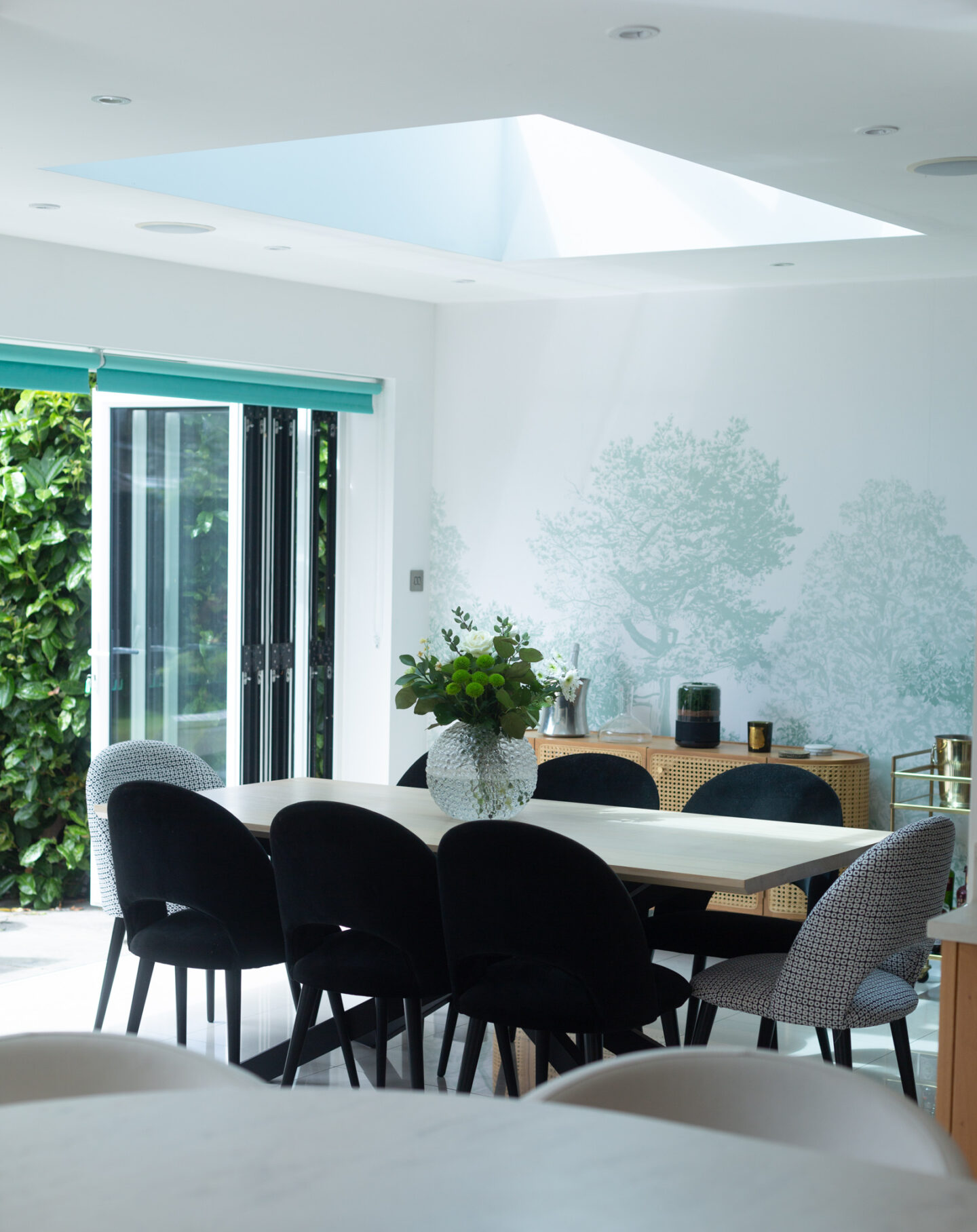 Brilliant White matt paint on the walls and ceiling of our light-filled dining room, alongside a green tree wall mural.