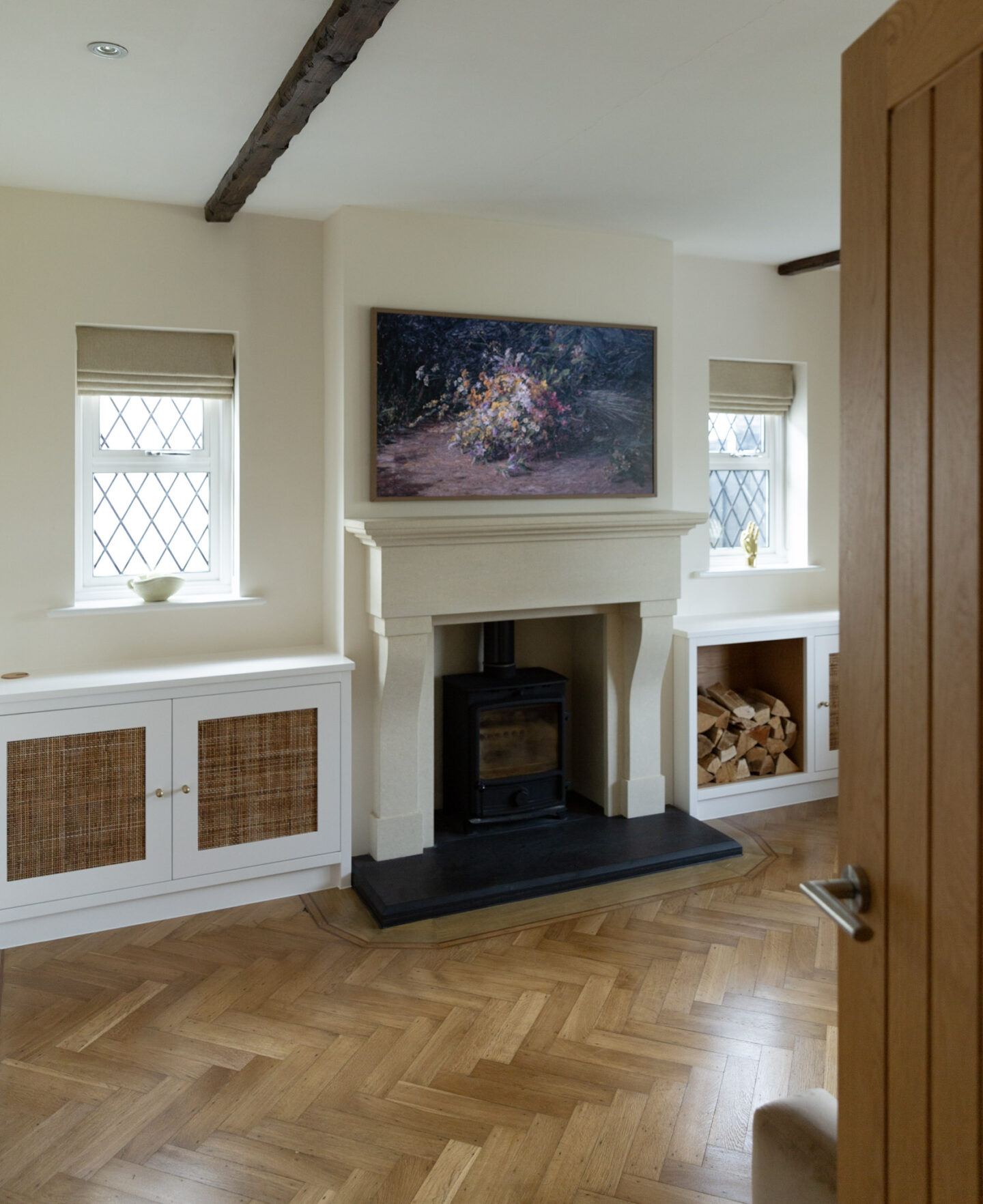 Fired Earth White Mulberry walls complementing a sandy limestone fireplace in a north-facing room.