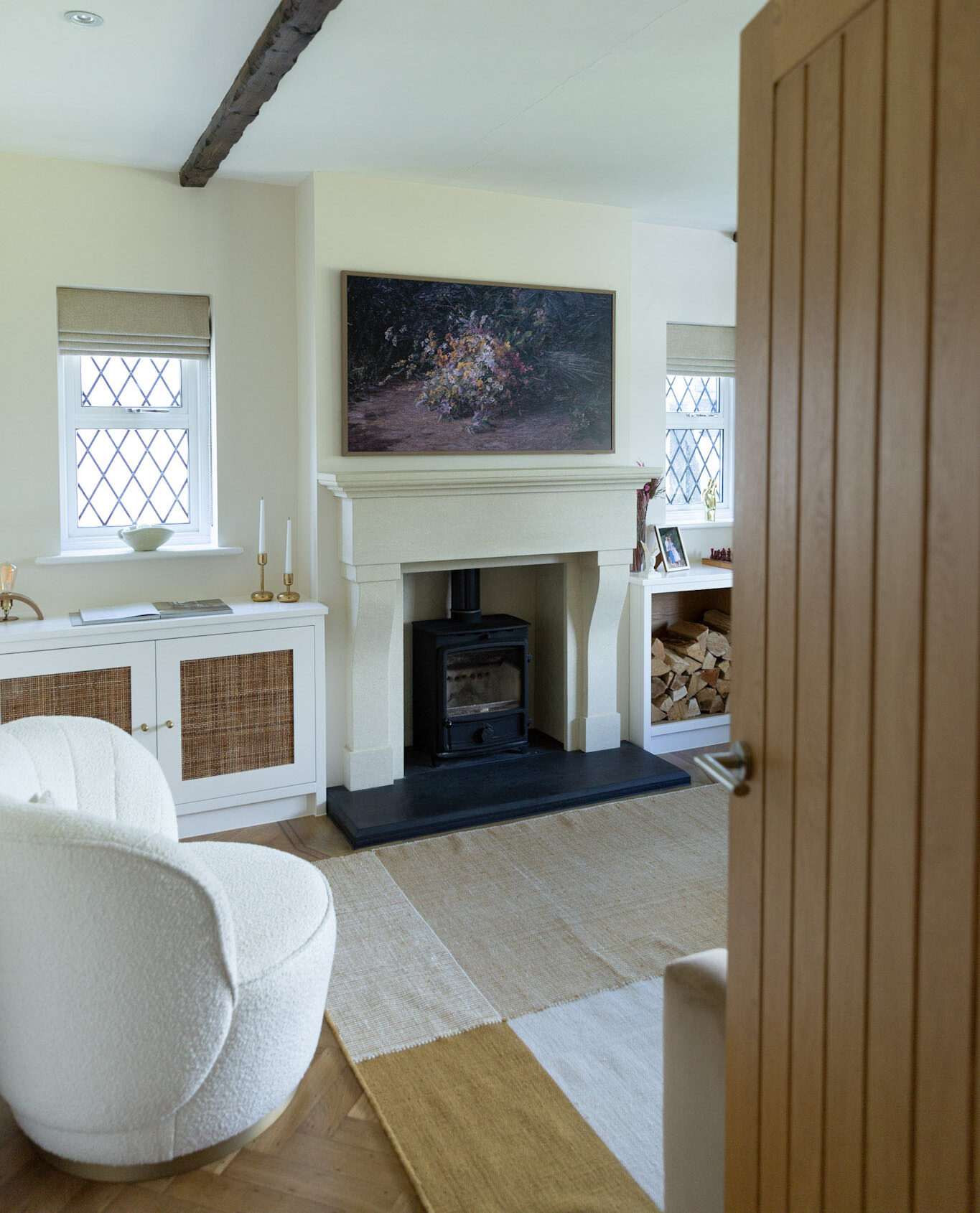 Cosy living room with a log burner, a rug and a boucle accent chair, creating a warm and inviting space for winter.