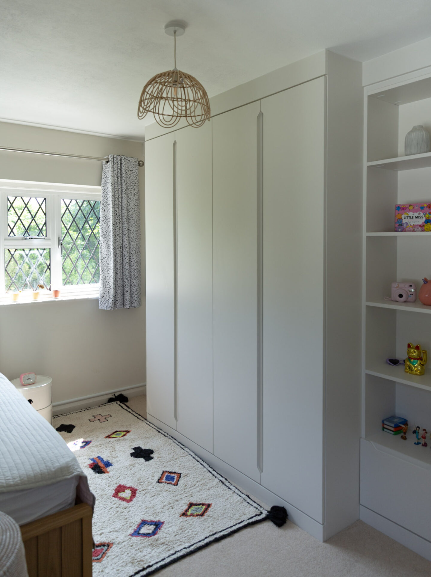 Custom built-in wardrobe in small bedroom with clean, sleek design