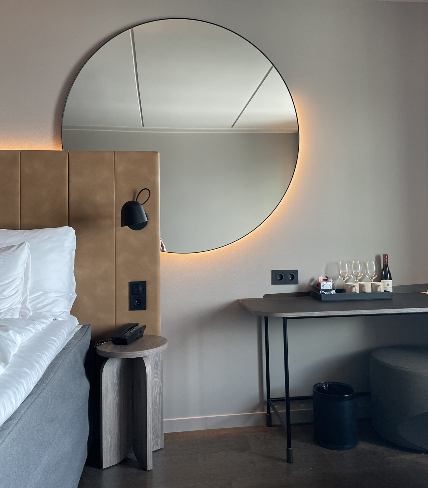 Large round mirror over bed headboard