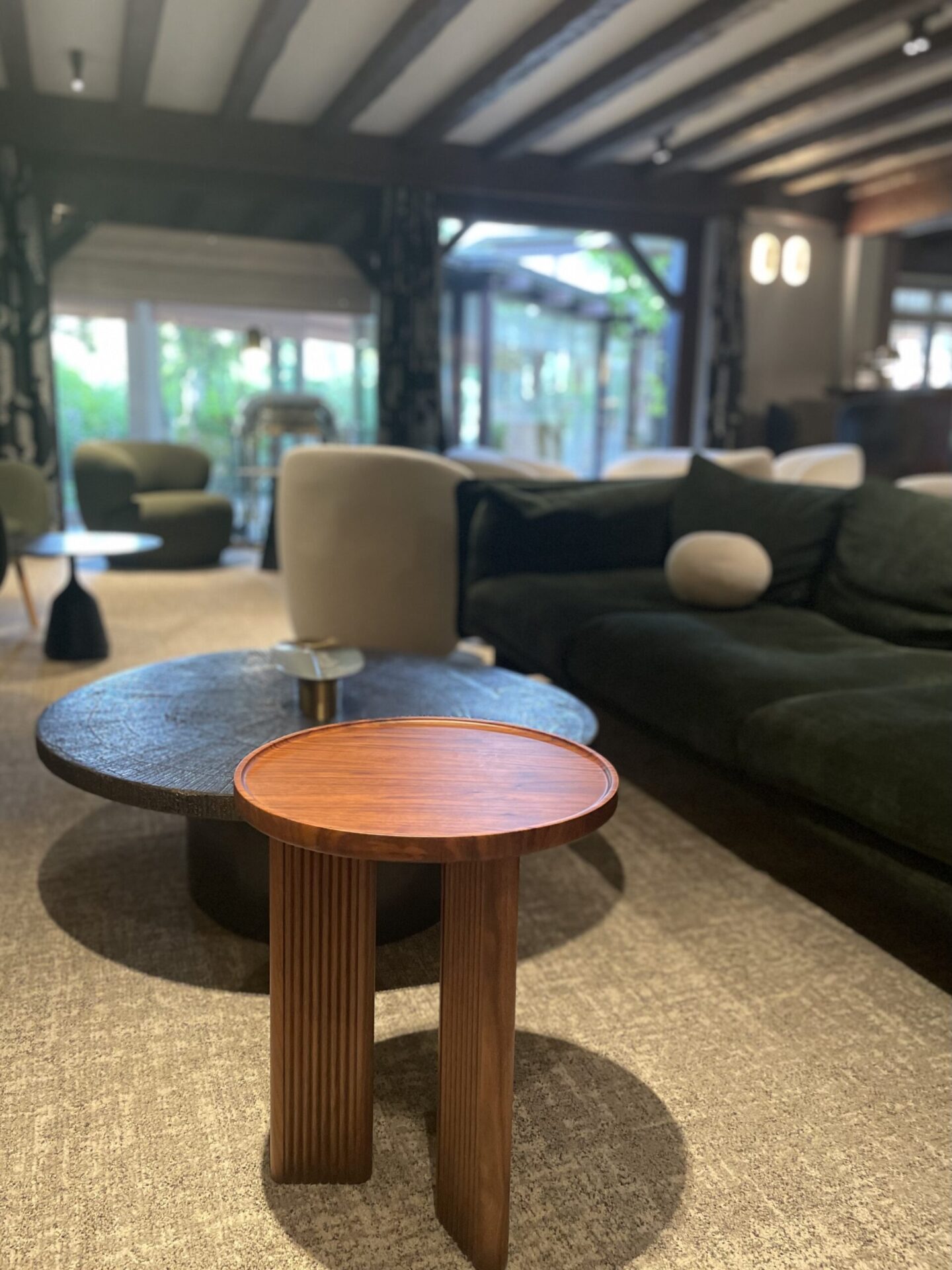 Round wooden tables with a lacquer finish in a large period home living room.