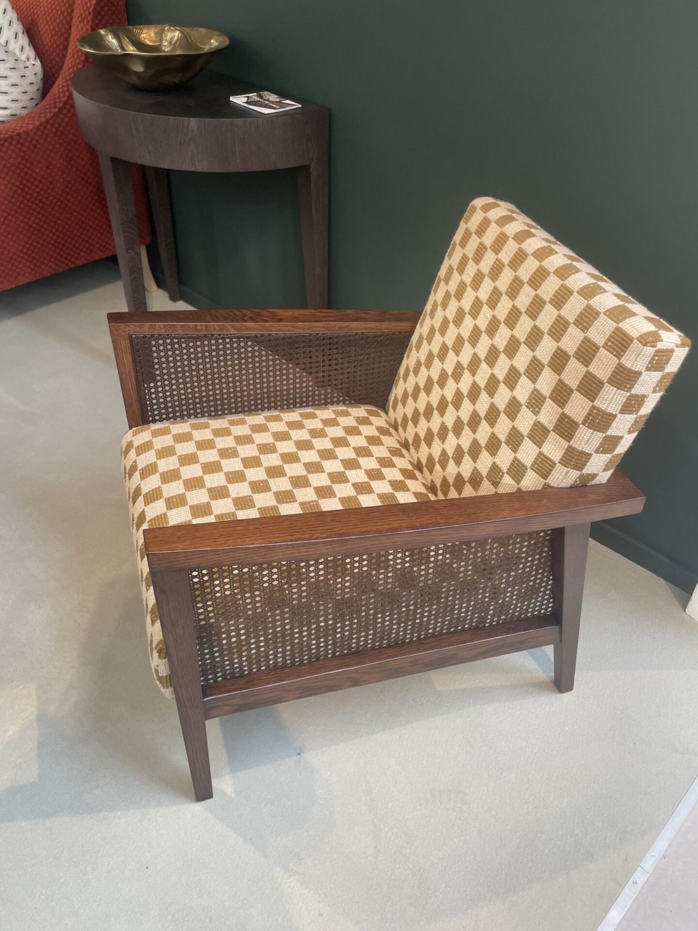 Rattan cane armchair with upholstered chequered fabric.