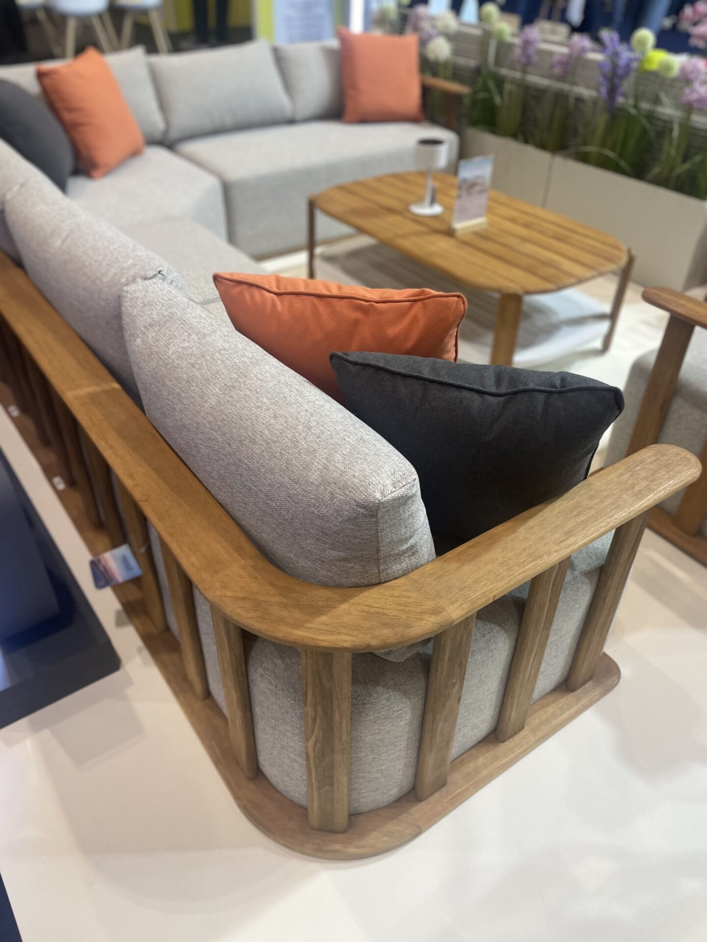 Modular teak garden set with grey cushions.