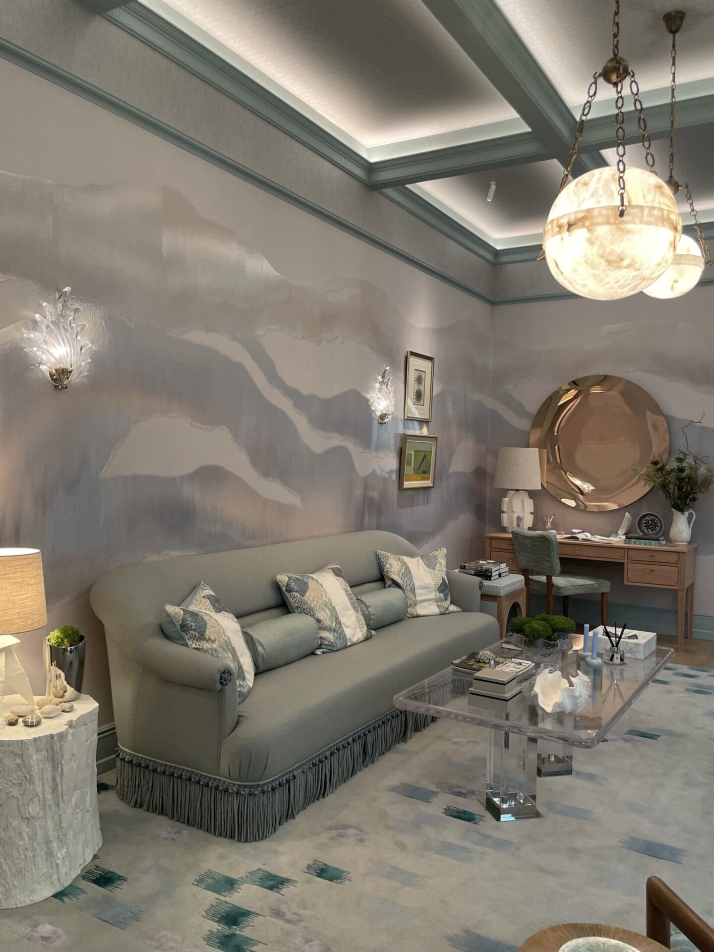 Grey colour-drenched living room with matching walls, furniture and decorative details creating a dramatic interior scheme