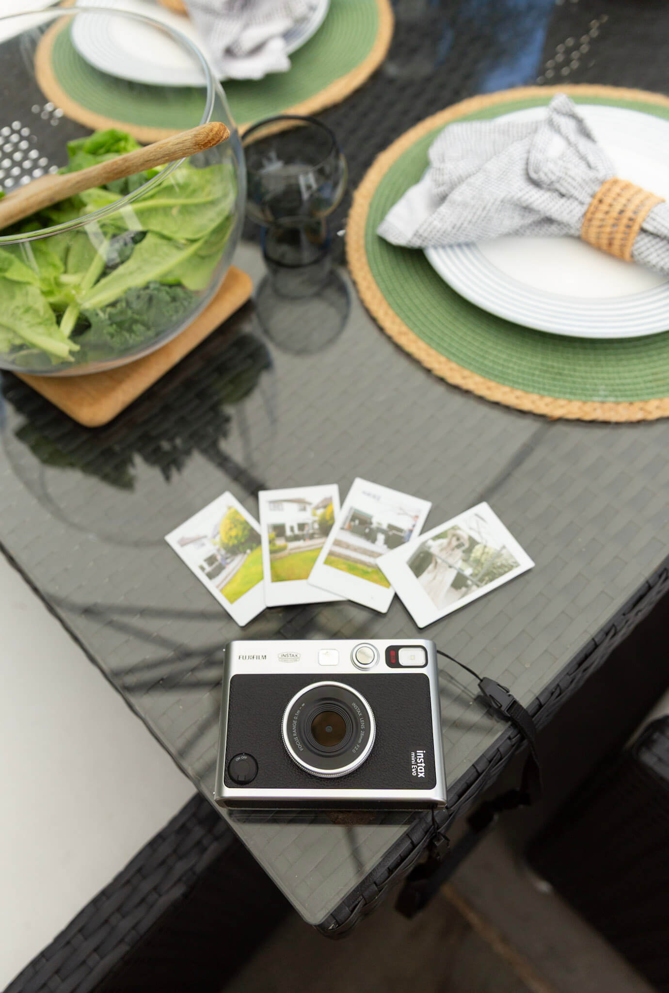 Close up of a Fujifilm Instax Mini Evo Instant Hybrid Camera with printed Instax photos arranged in a flat lay