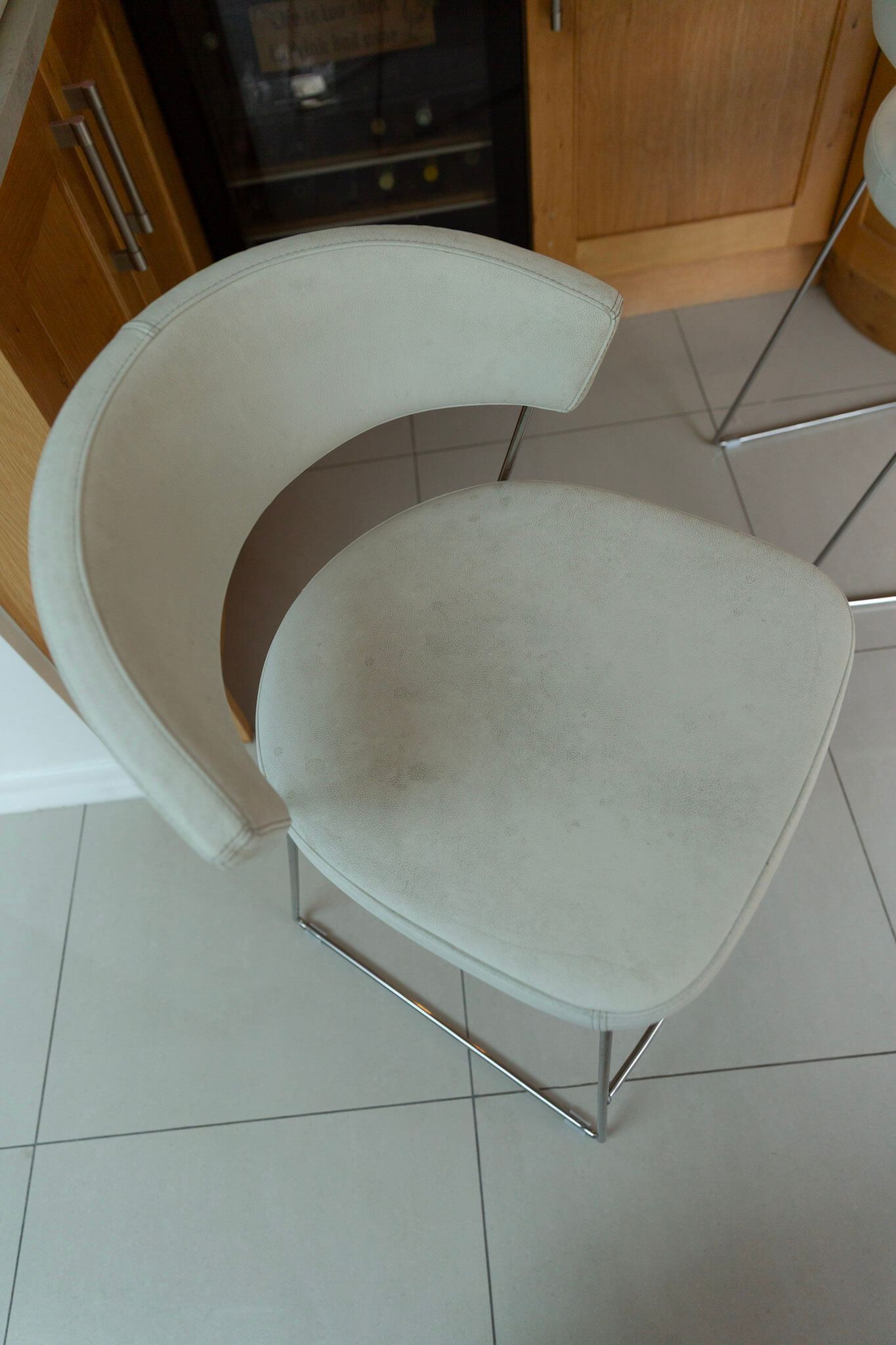 White Calligaris leather bar stool showing wear and discolouration before restoration.