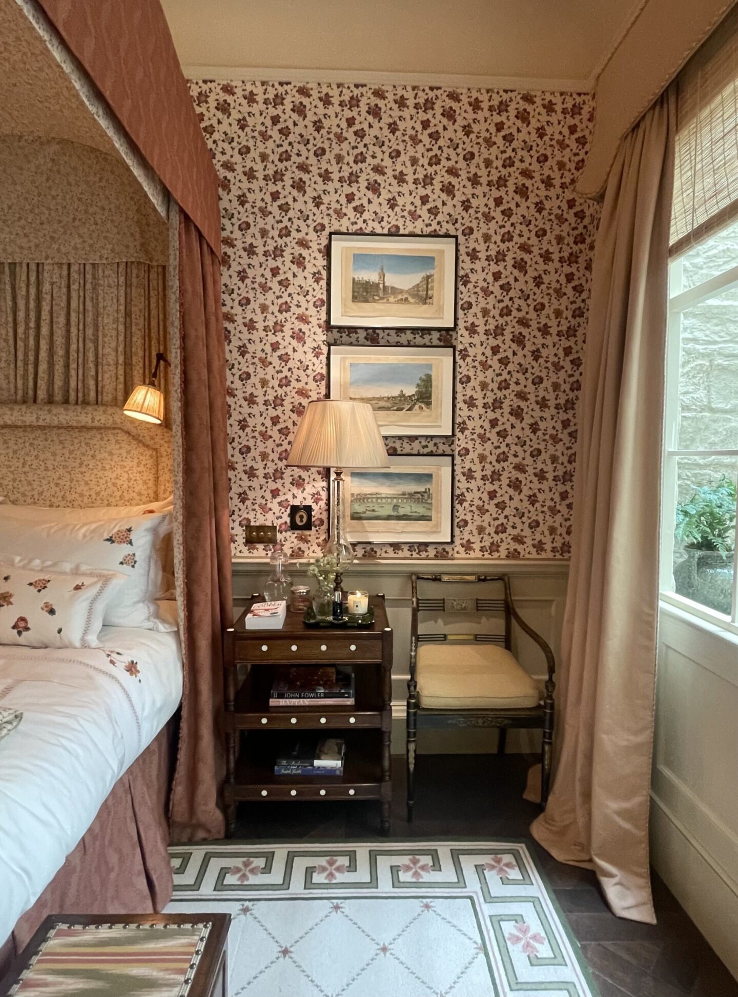 Traditional home interior design with patterned wallpaper and a four-poster bed