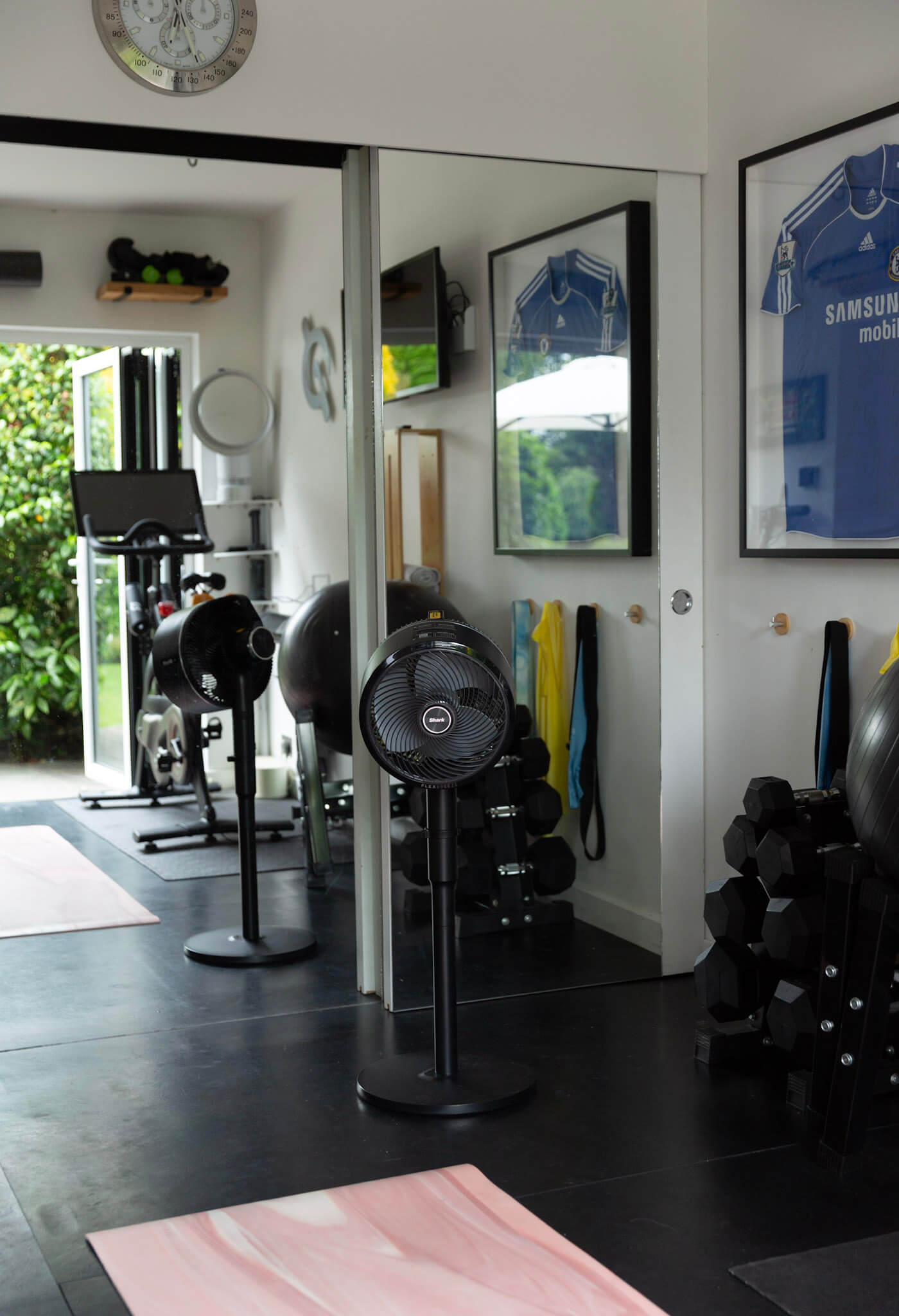 A portable fan is being used as a pedestal fan in the home gym