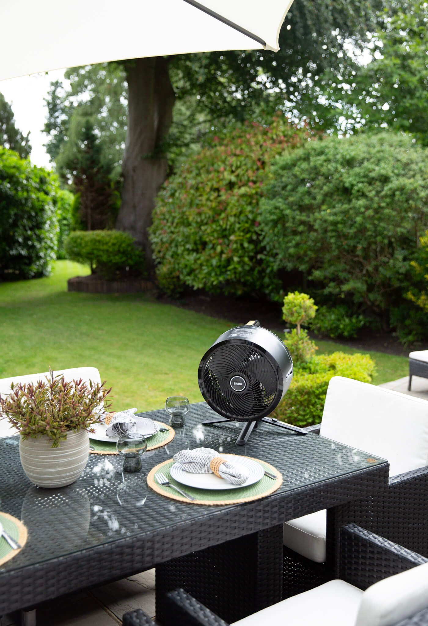 Outdoor dining table with a Shark FlexBreeze cordless fan and table set for summer garden entertaining
