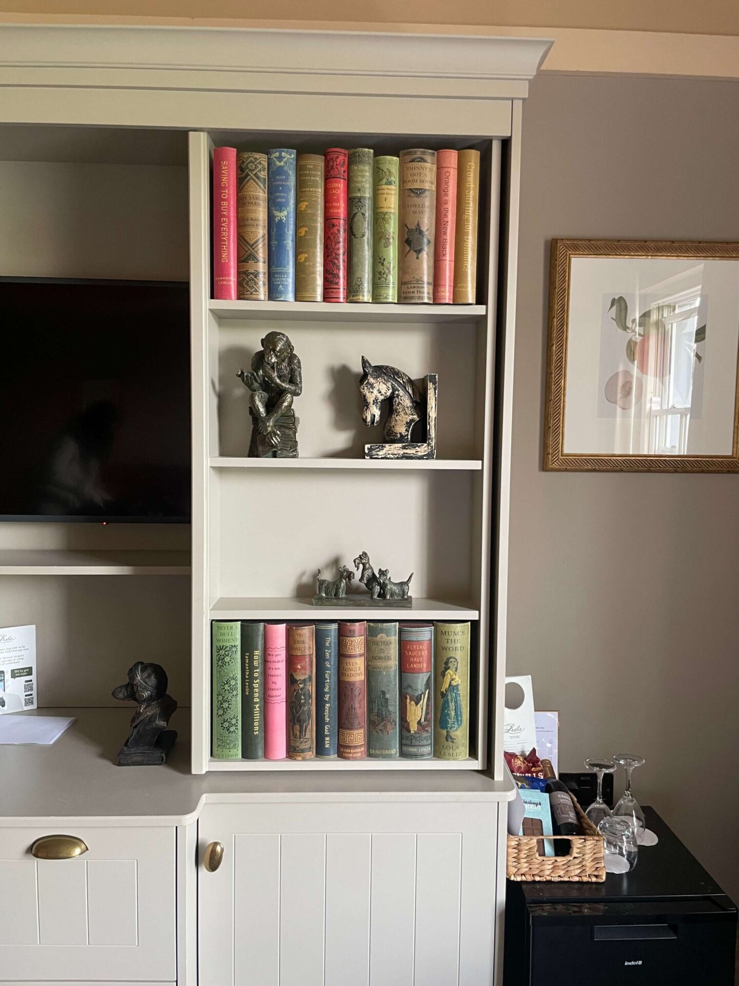 Shaker-style bookcase in a Classic Twin Room at Castle Leslie Estate, displaying books, horse-themed artwork, and decorative ornaments.