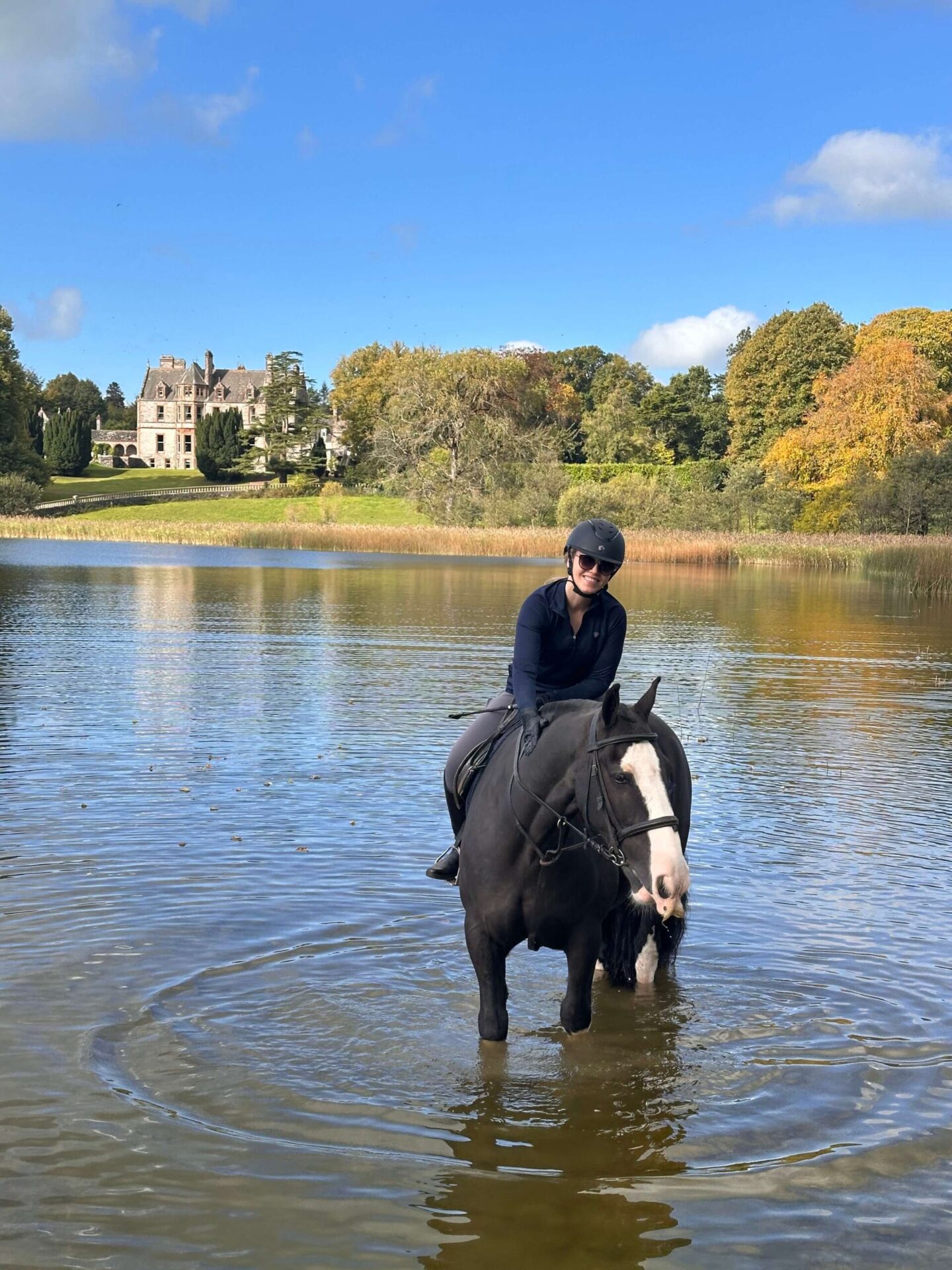 Horse rider in front of Castle Leslie Estate in Ireland, showcasing the estate's equestrian heritage and luxury setting.