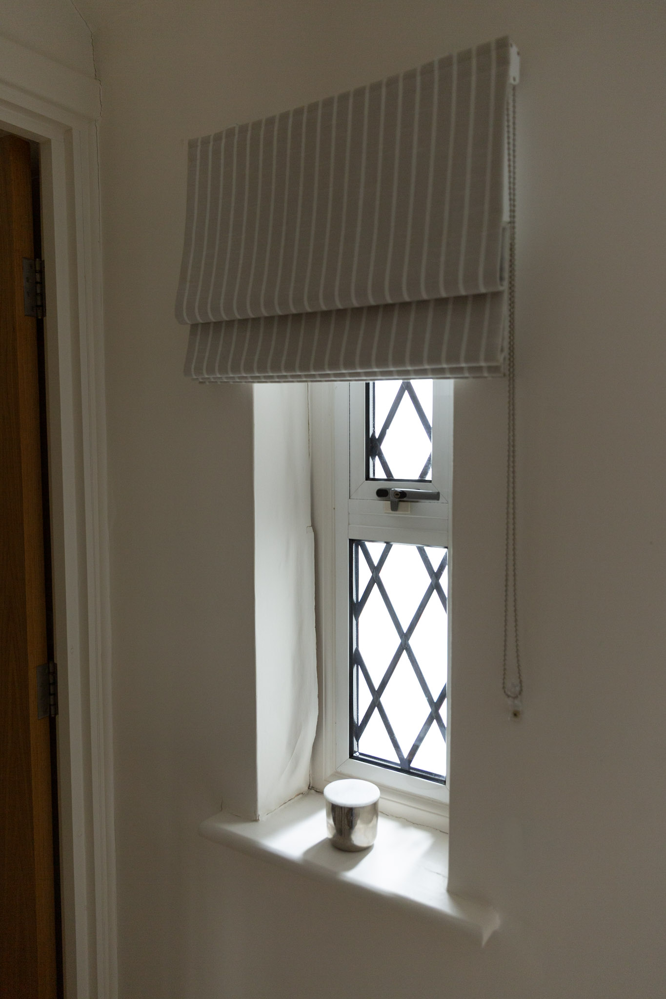 Peeling lining paper near a window caused by moisture damage