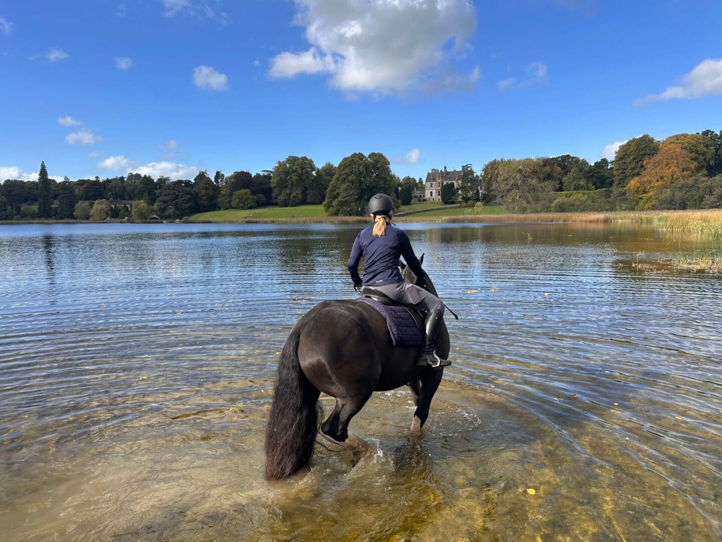 Horse riding through the grounds of Castle Leslie Estate beside the lake.
