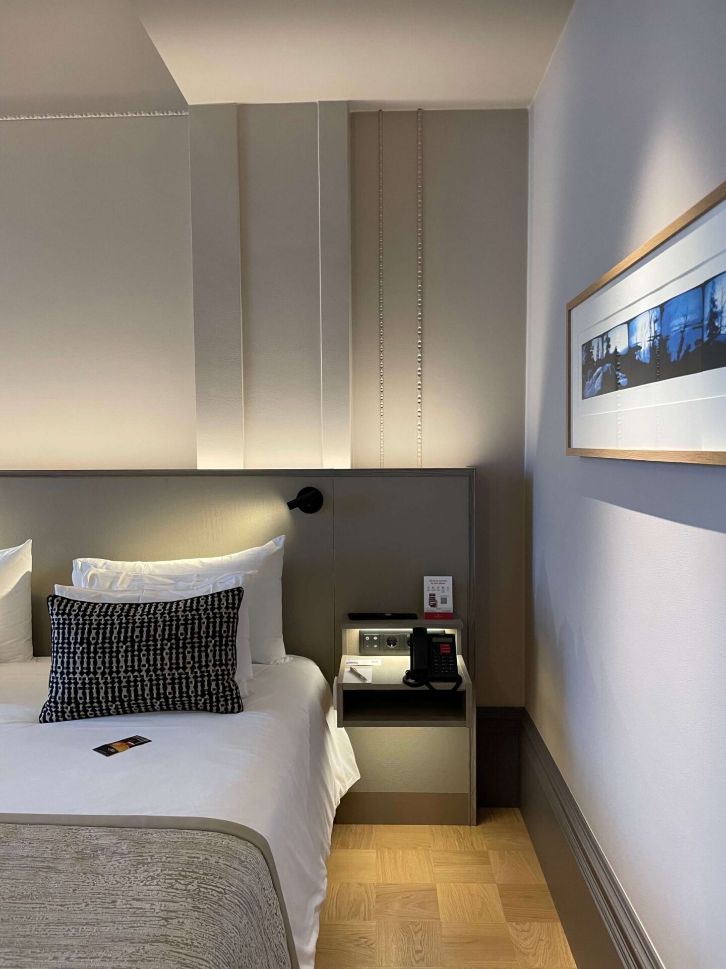 Decorative coving on the walls and Finnish art in hotel bedroom.