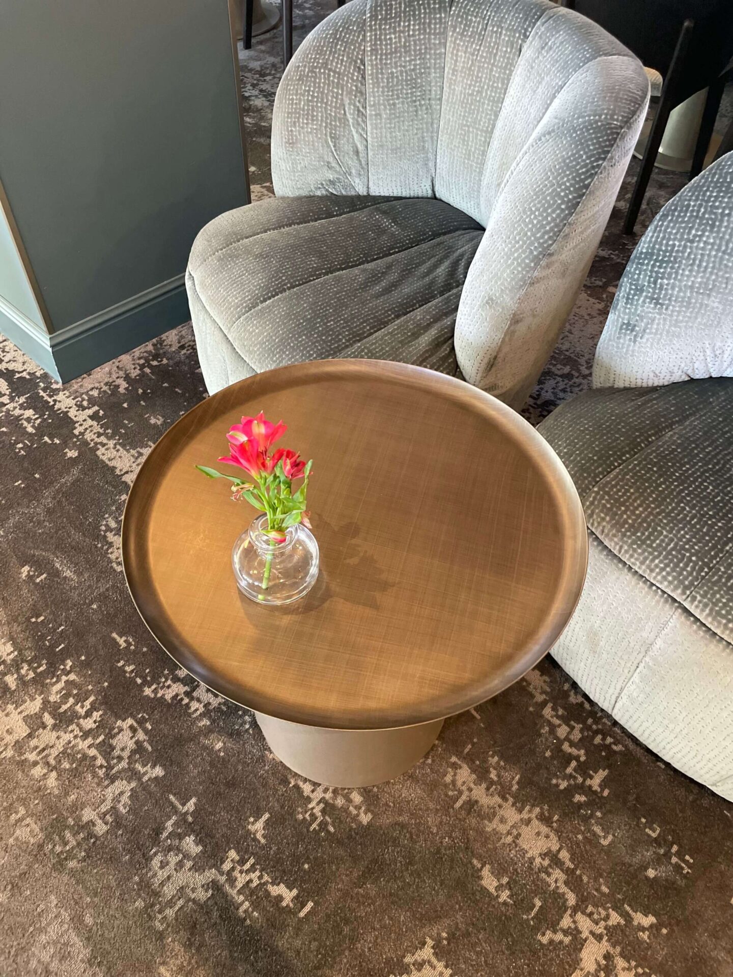 Luxurious coffee table surrounded by upholstered velvet chairs in the hotel lounge.