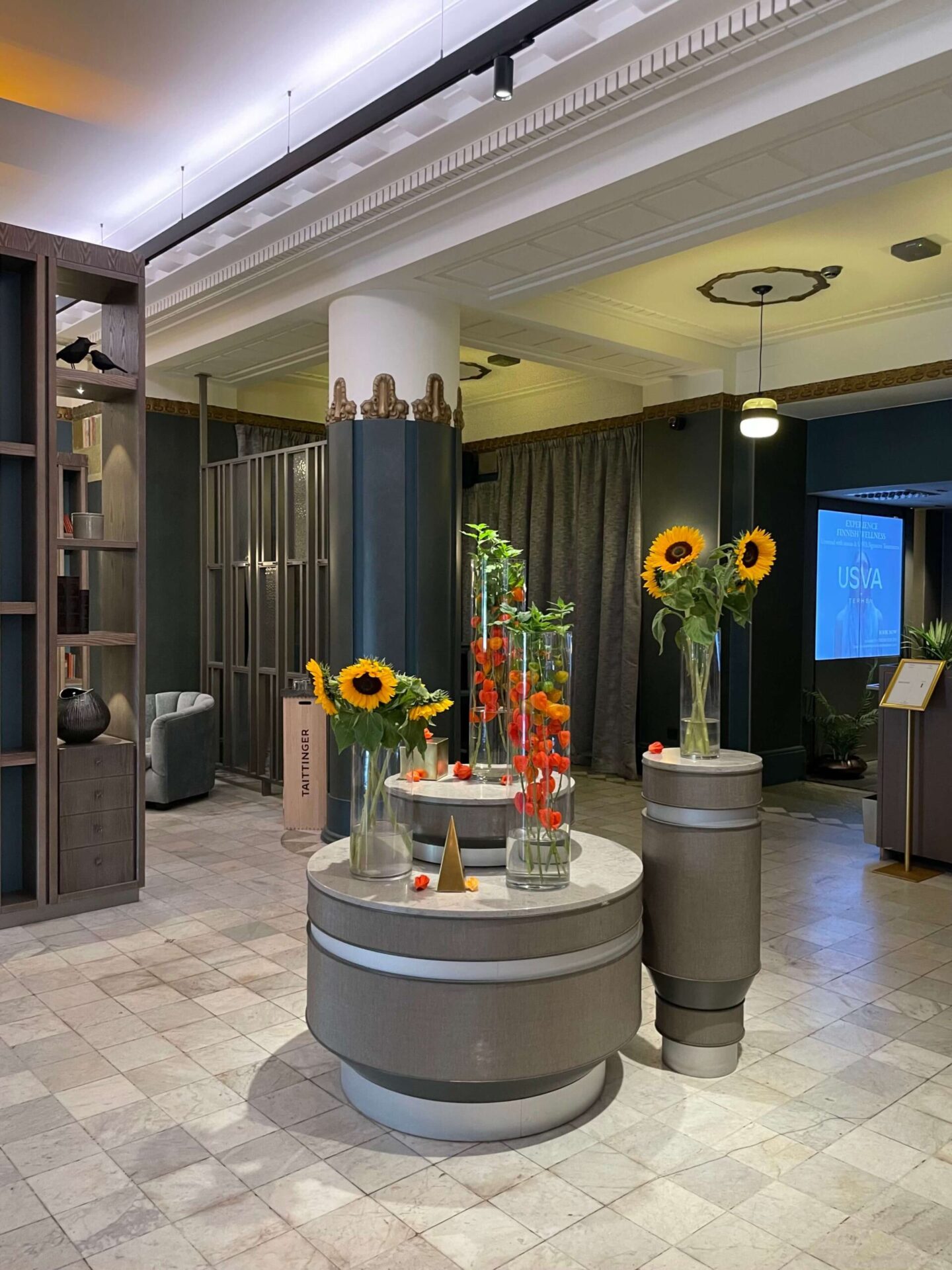 Flowers in vases arranged as a centrepiece on a round table in the lounge at NH Collection Helsinki Grand Hansa.