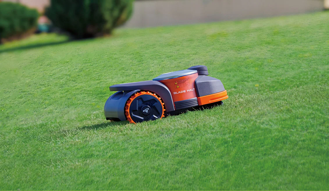 Navimow robot lawn mower cutting grass on a garden lawn.