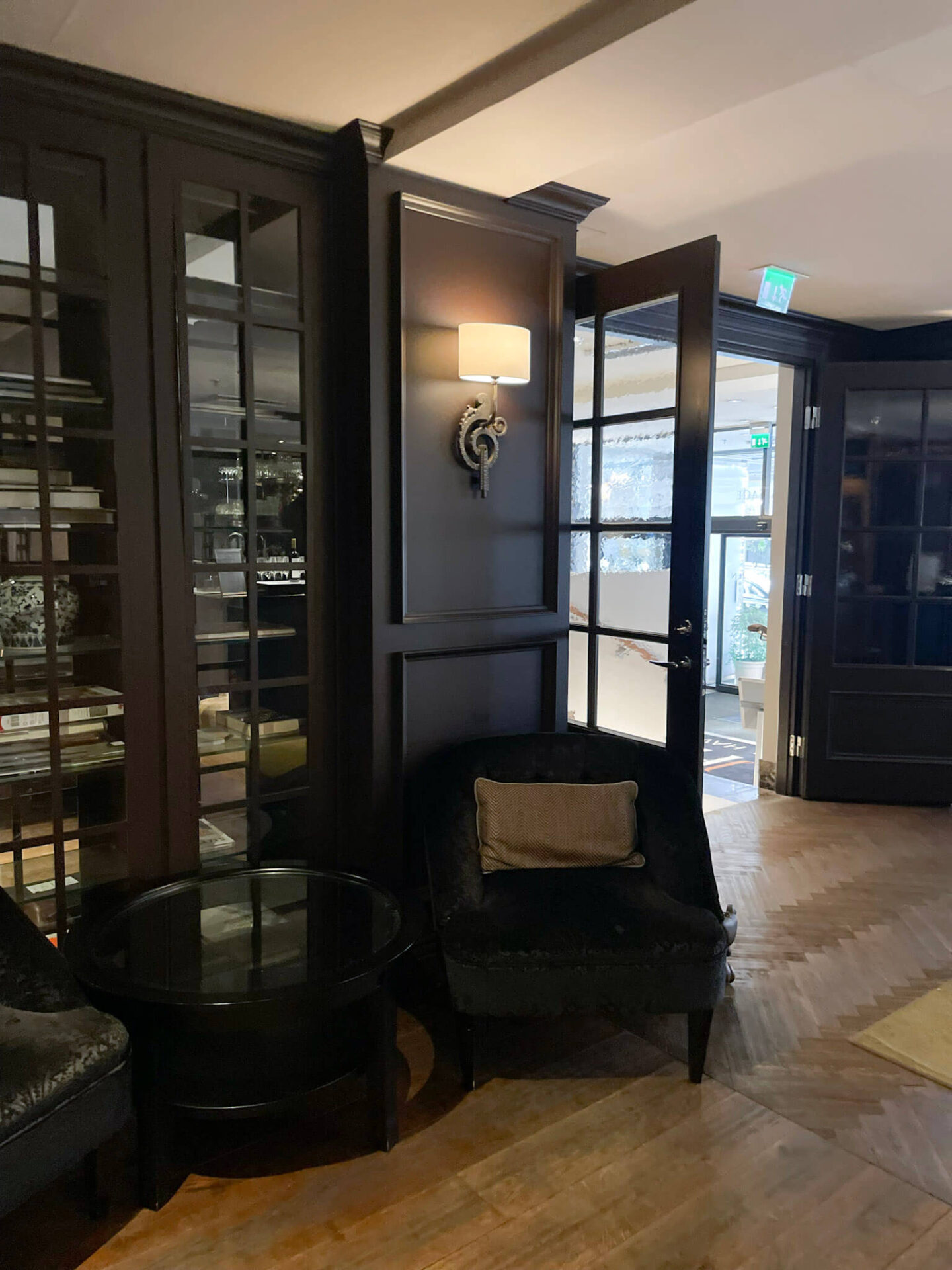 Dark built-in bookcase blending into moody interior walls at Hotel Haven Helsinki