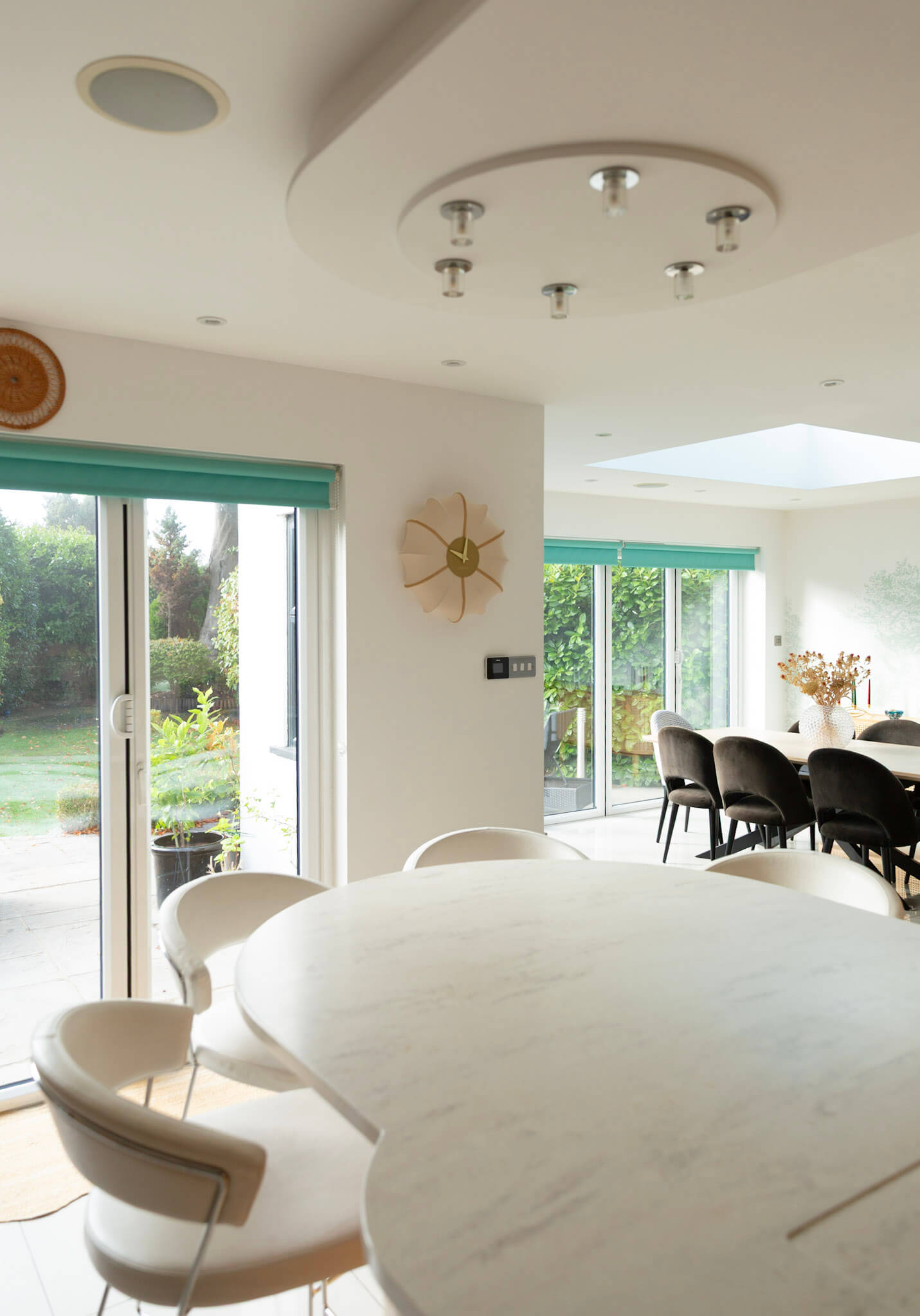 NeXtime Ultimo beige fabric wall clock styled in an open-plan kitchen and dining space