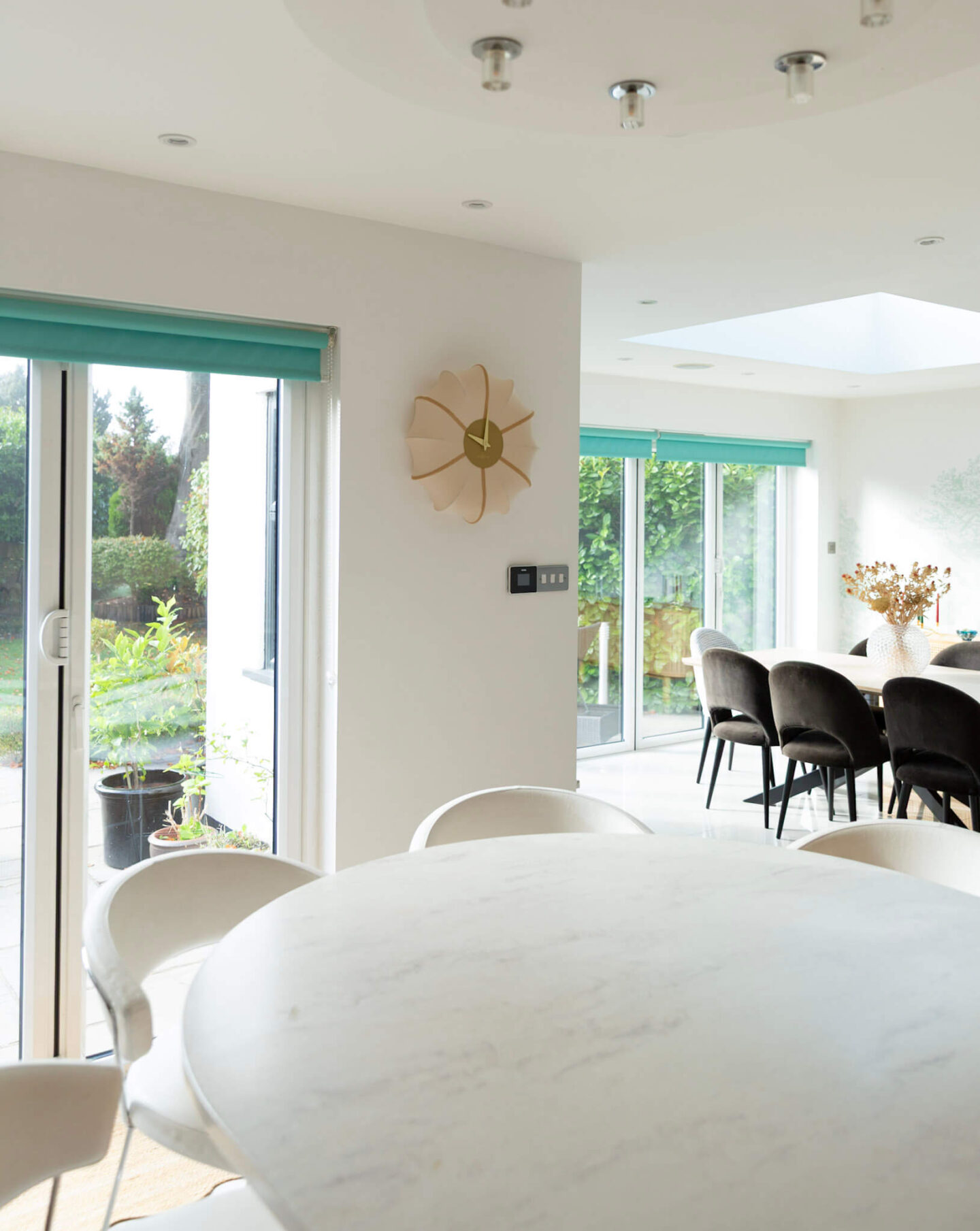 Sculptural NeXtime Ultimo wall clock displayed against a white wall in a neutral open-plan kitchen